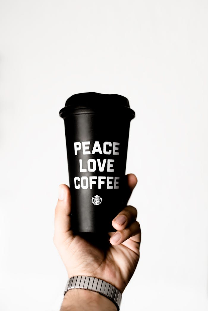Mastering the First Impression: Your intriguing post title goes here Close-up of a hand holding a coffee cup with 'Peace Love Coffee' text, promoting positivity.